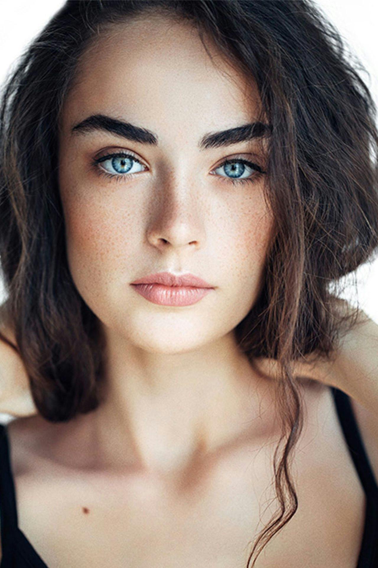 woman with brown hair, blue eyes, and freckles
