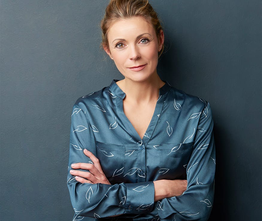 Woman in silk shirt with arms crossed