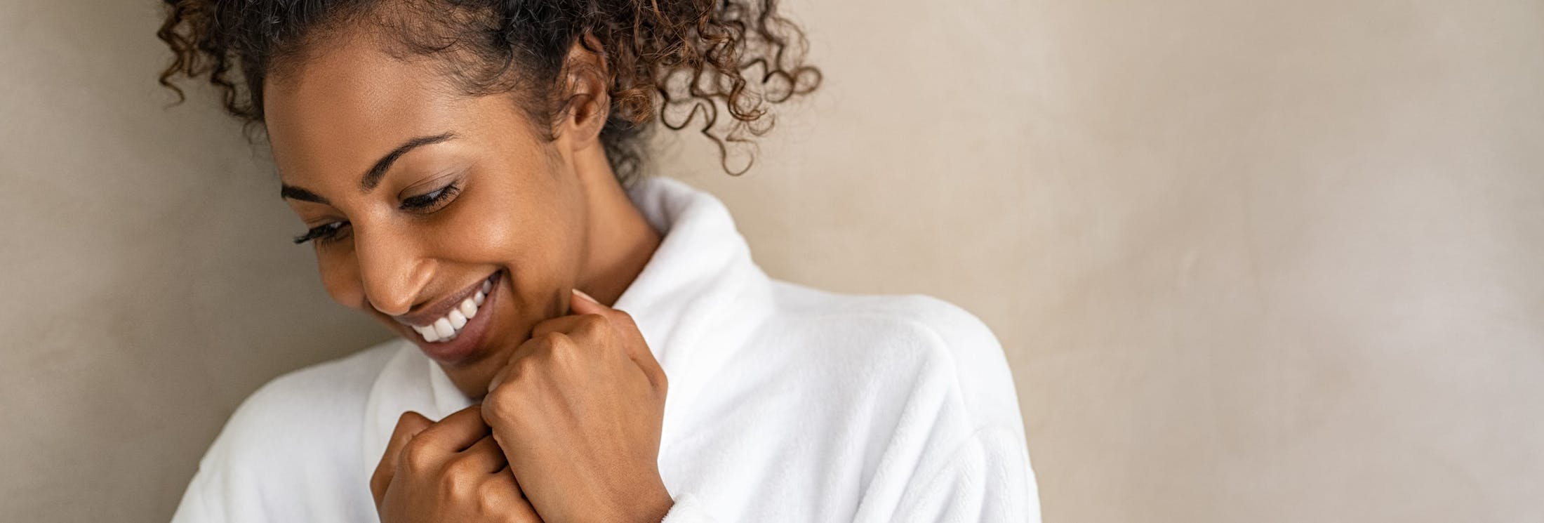 woman holding the collar of her shirt smiling