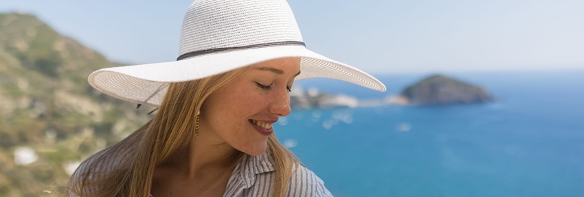 woman in white hat looking to the right smiling