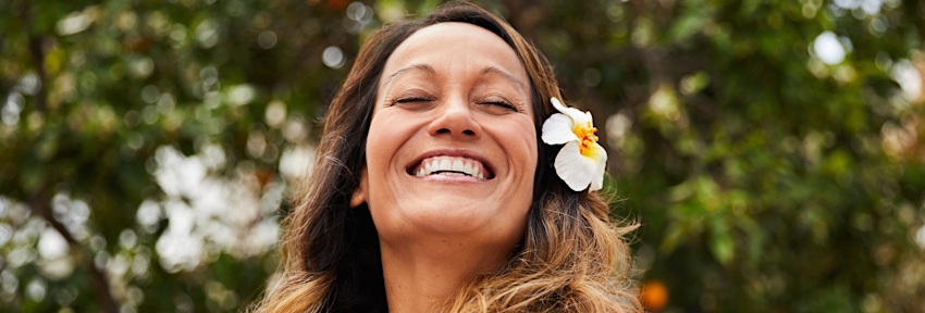woman with flower in her hair smiling