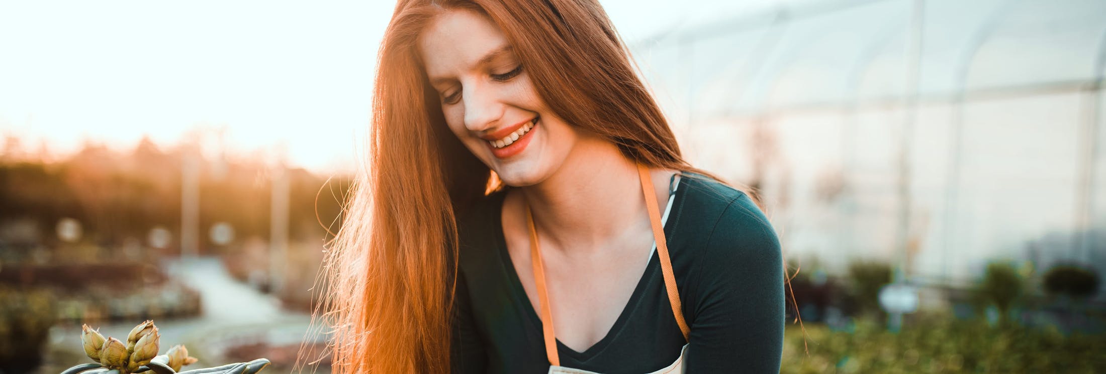 woman with red hair smiling facing downwards