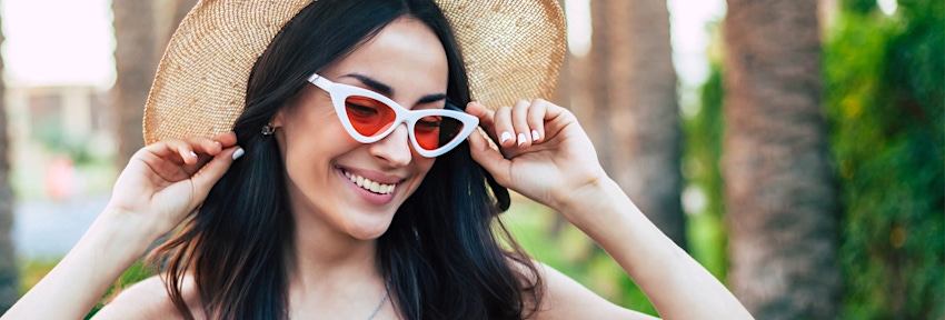 woman in hat and sunglasses smiling