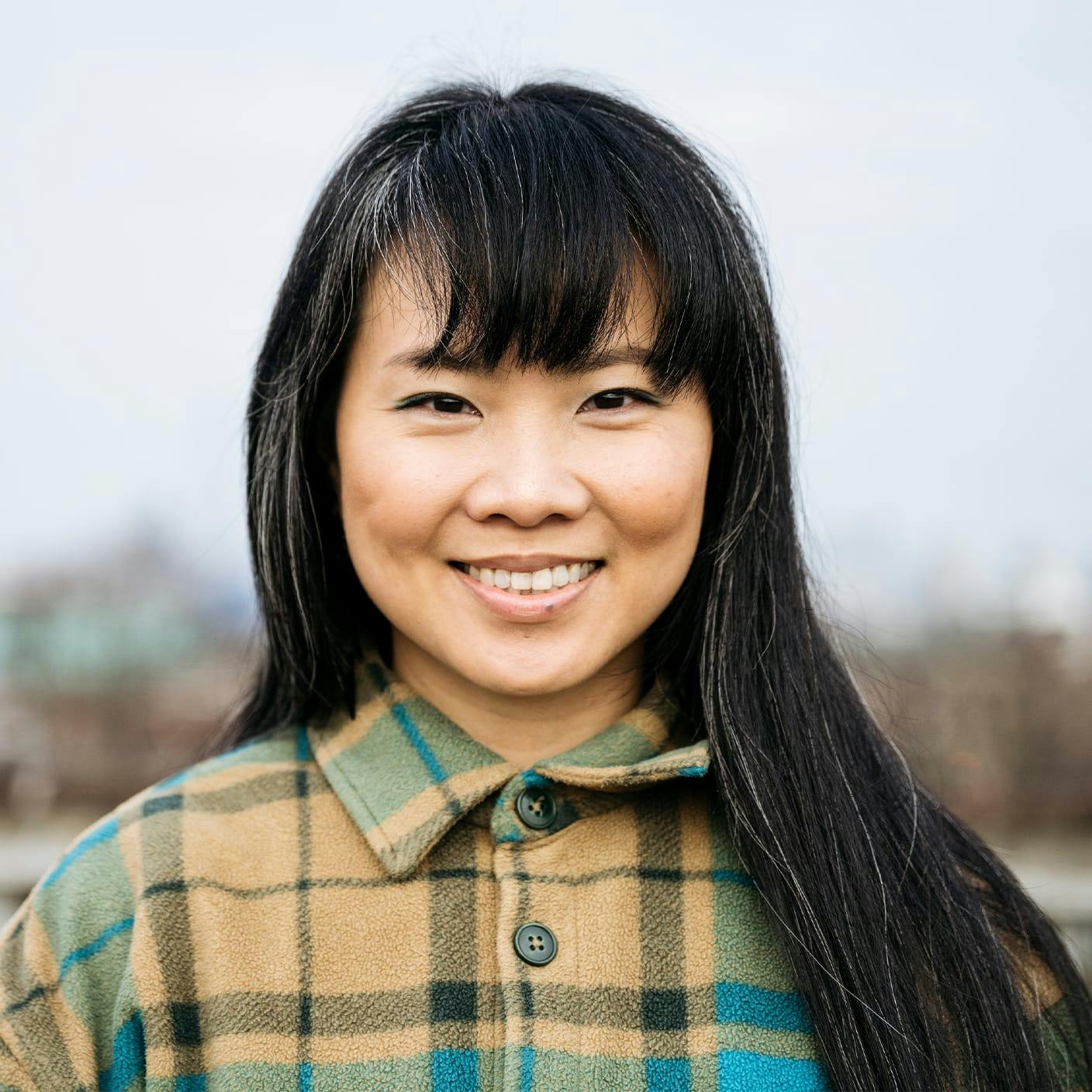 woman with long dark hair with a little bit of grey