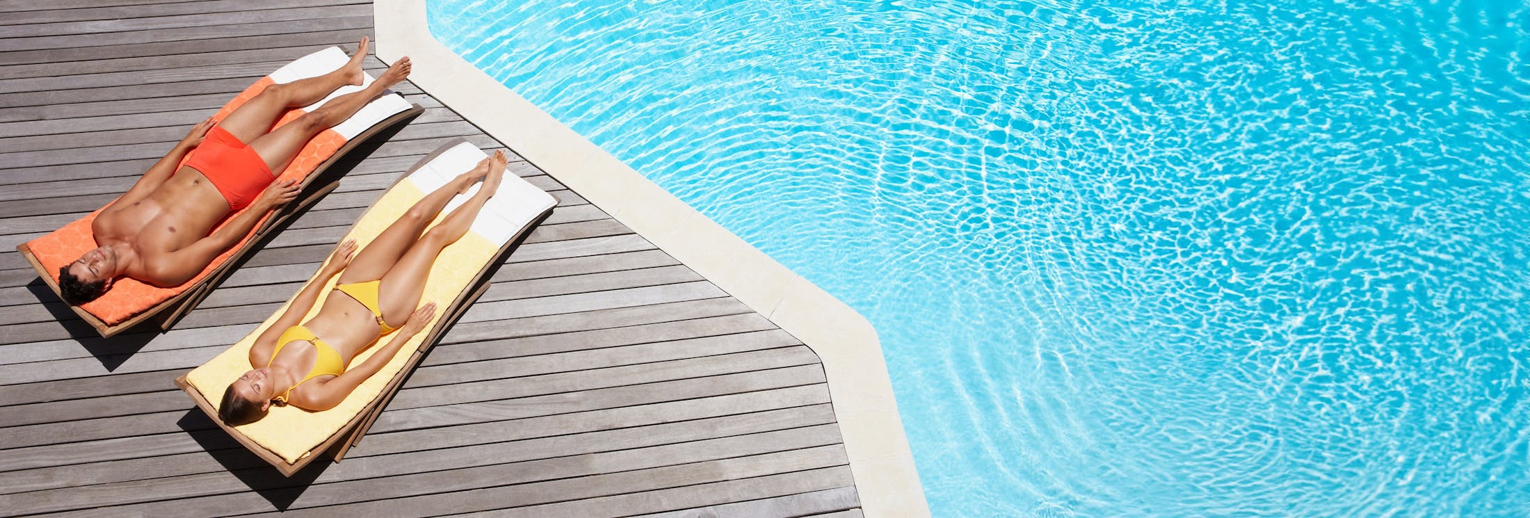 Two people lounging by the pool