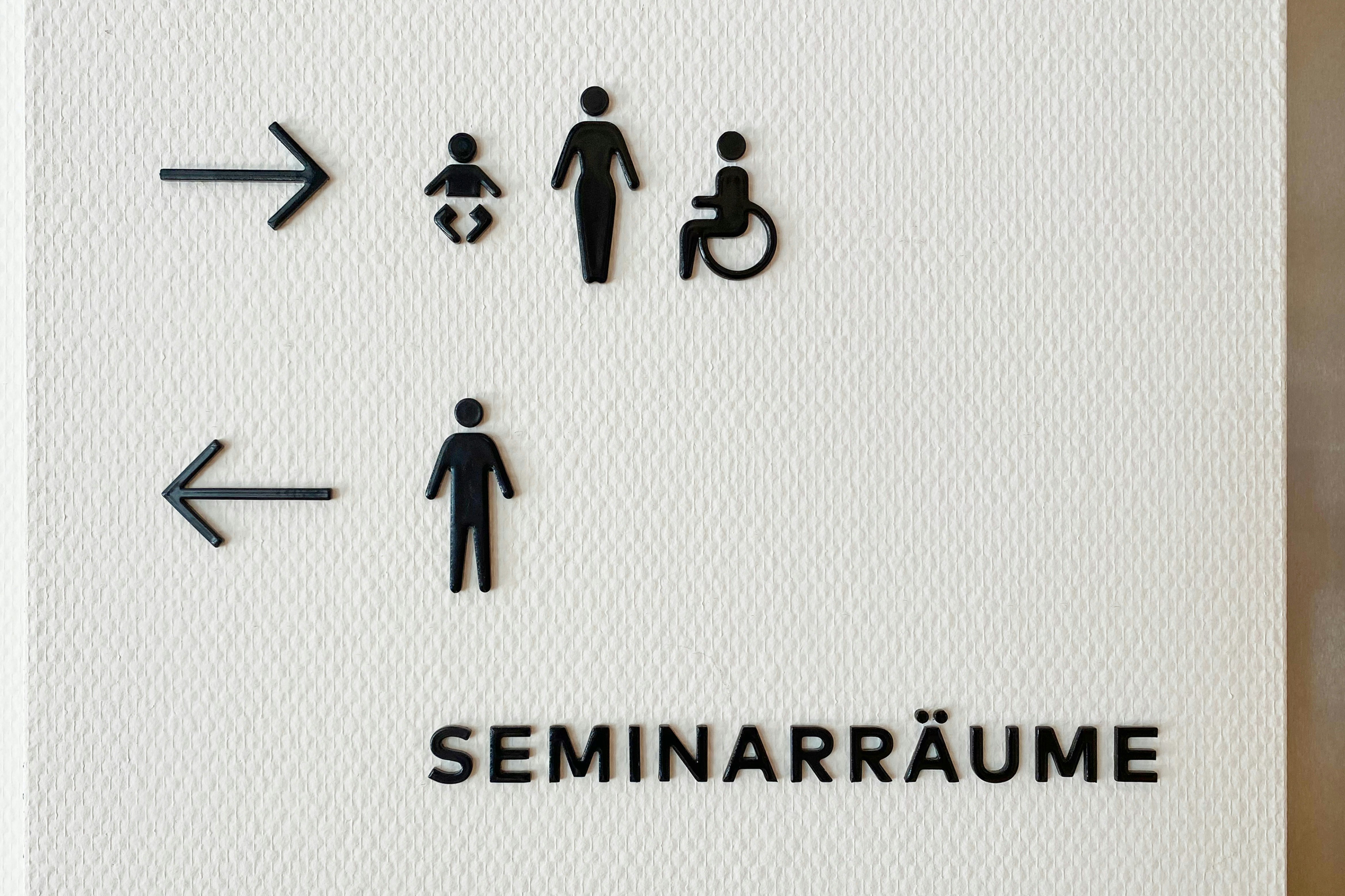 Lettres et pictogrammes émaillés sur mur blanc
