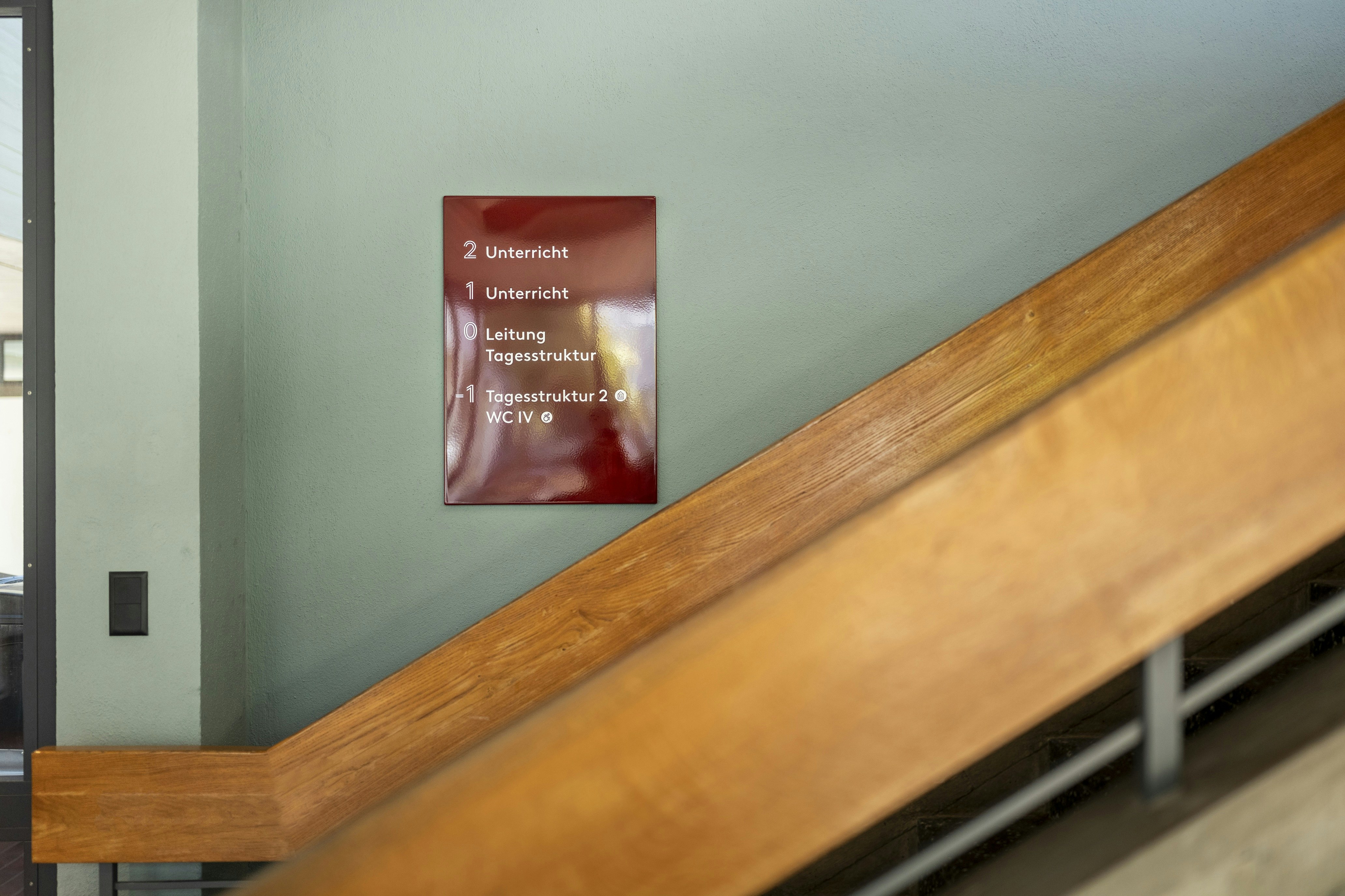 Rot emailliertes Emailleschild an hellgrüner Wand