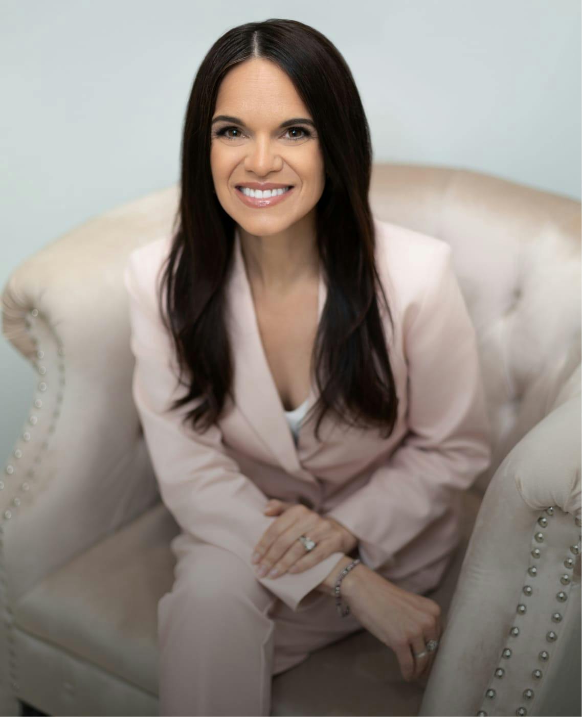 Woman in a pink jacket sitting in a chair