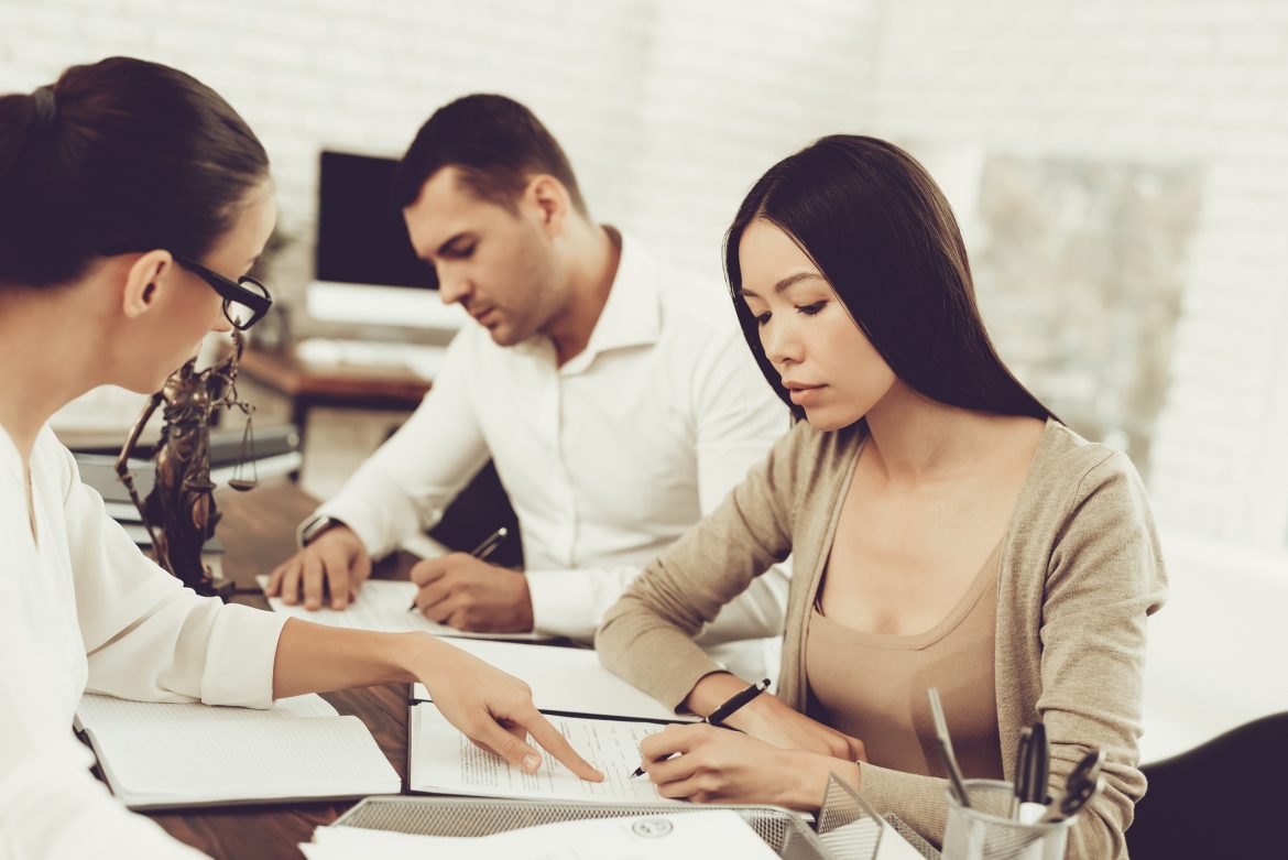 man and woman signing prenuptial agreement