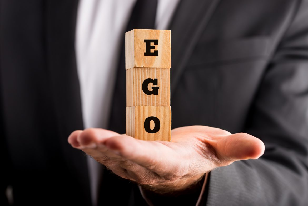 man holding wooden blocks marked with 'EGO'