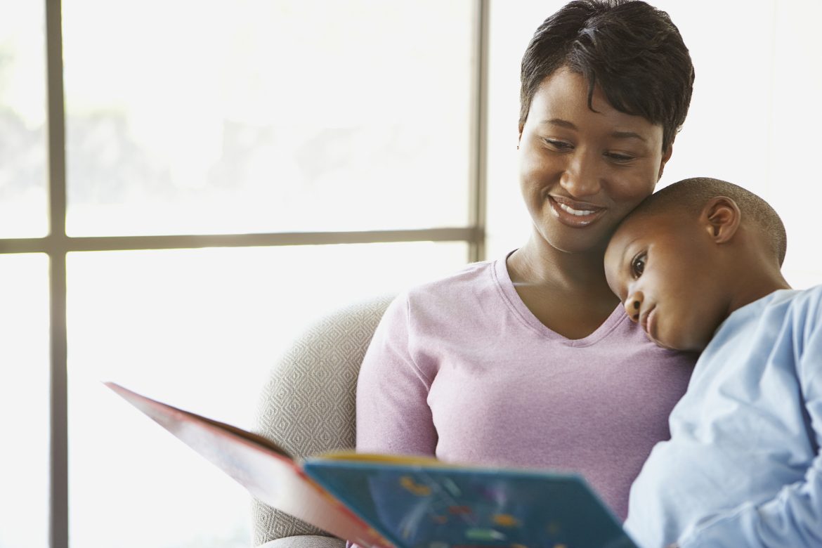 mother reading a book to her son 