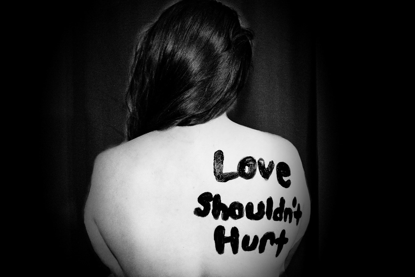 black and white image of back of woman- domestic violence concept