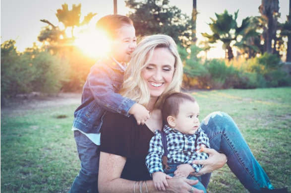 woman outdoors playing with her sons