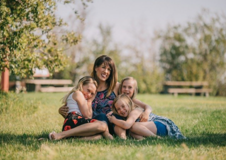 woman and daughters outdoors smiling