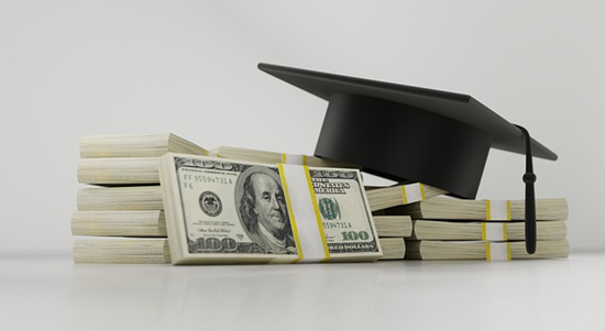 graduation hat on a pile of cash