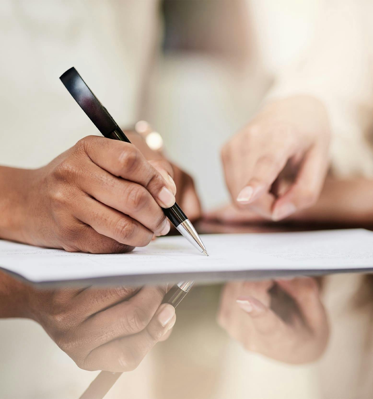 person writing on paperwork