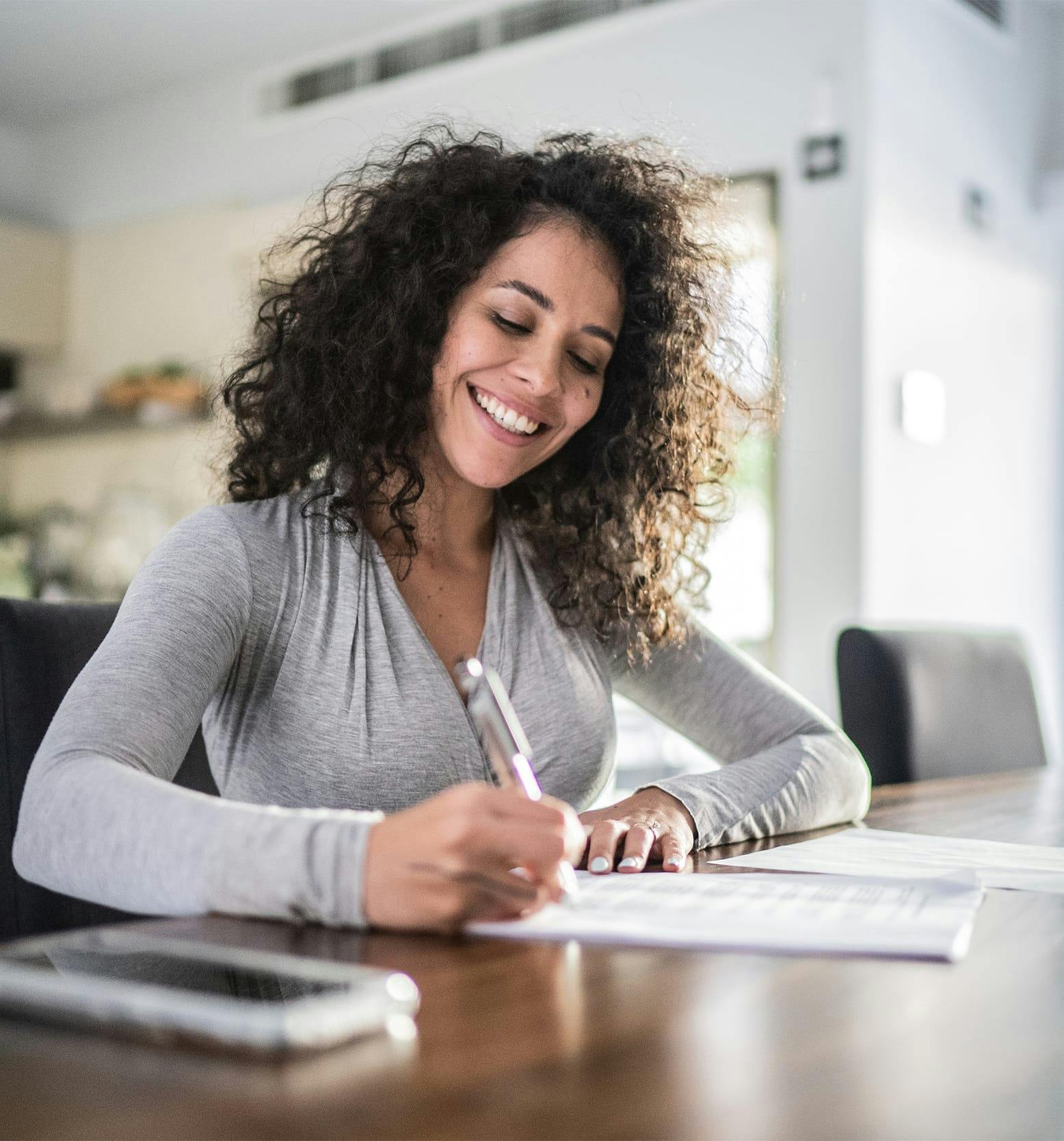 woman smiling while filling out form
