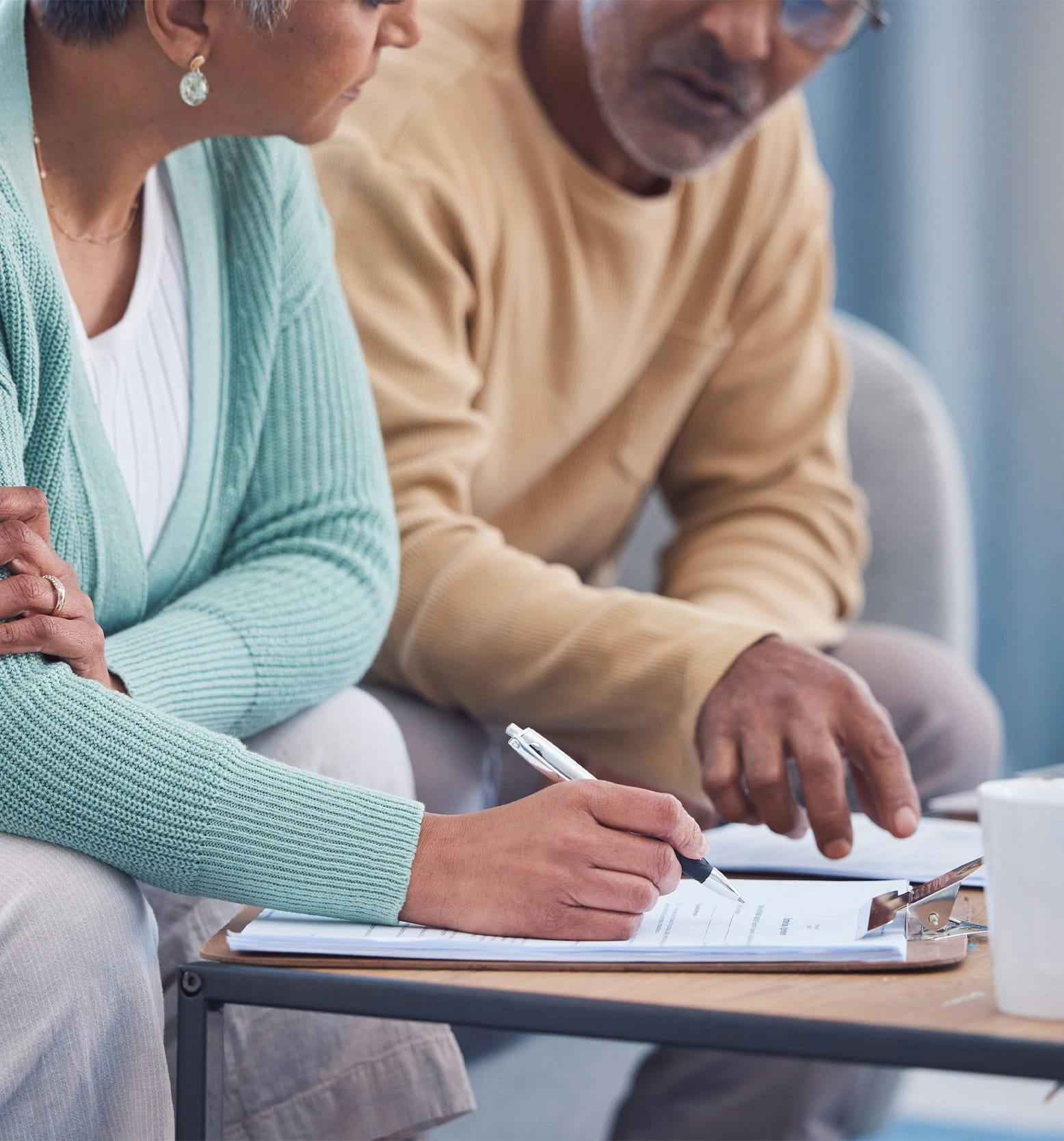 couple sitting next to each other filling out form
