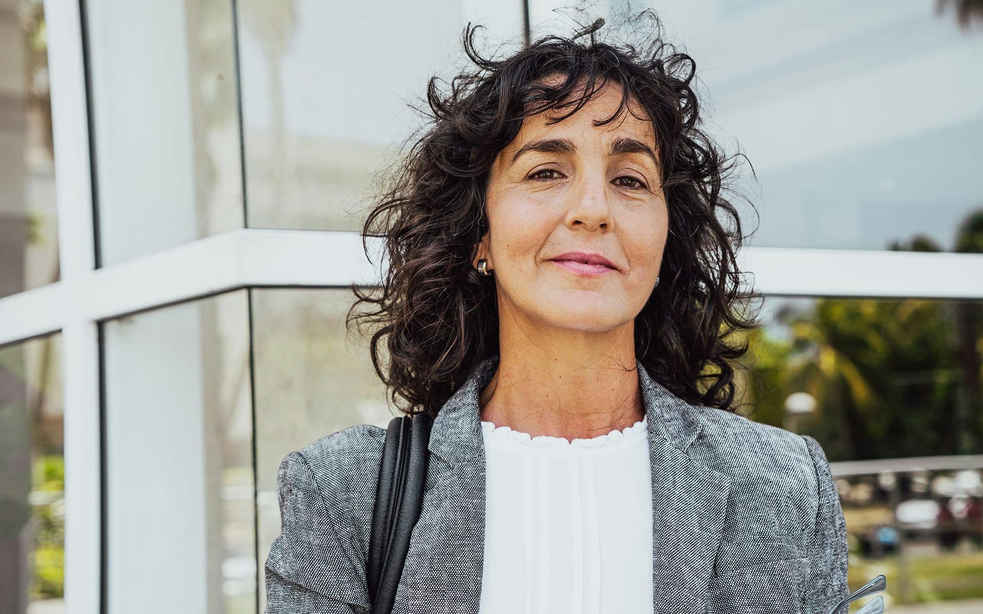 woman smirking forward in front of building