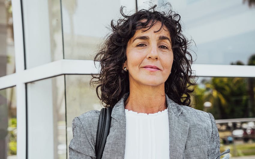 woman smirking forward in front of building