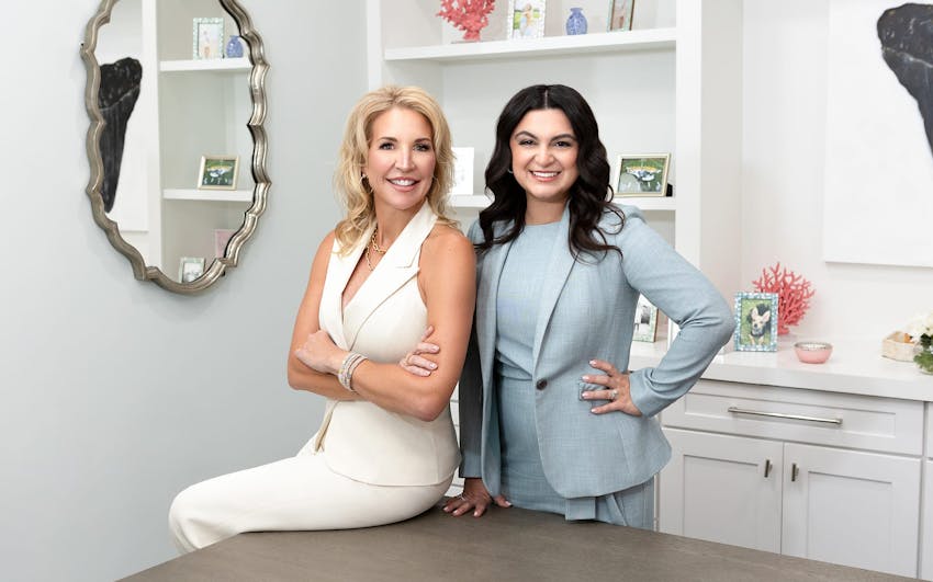 Heather Quick sitting on table and Anne posing next to her