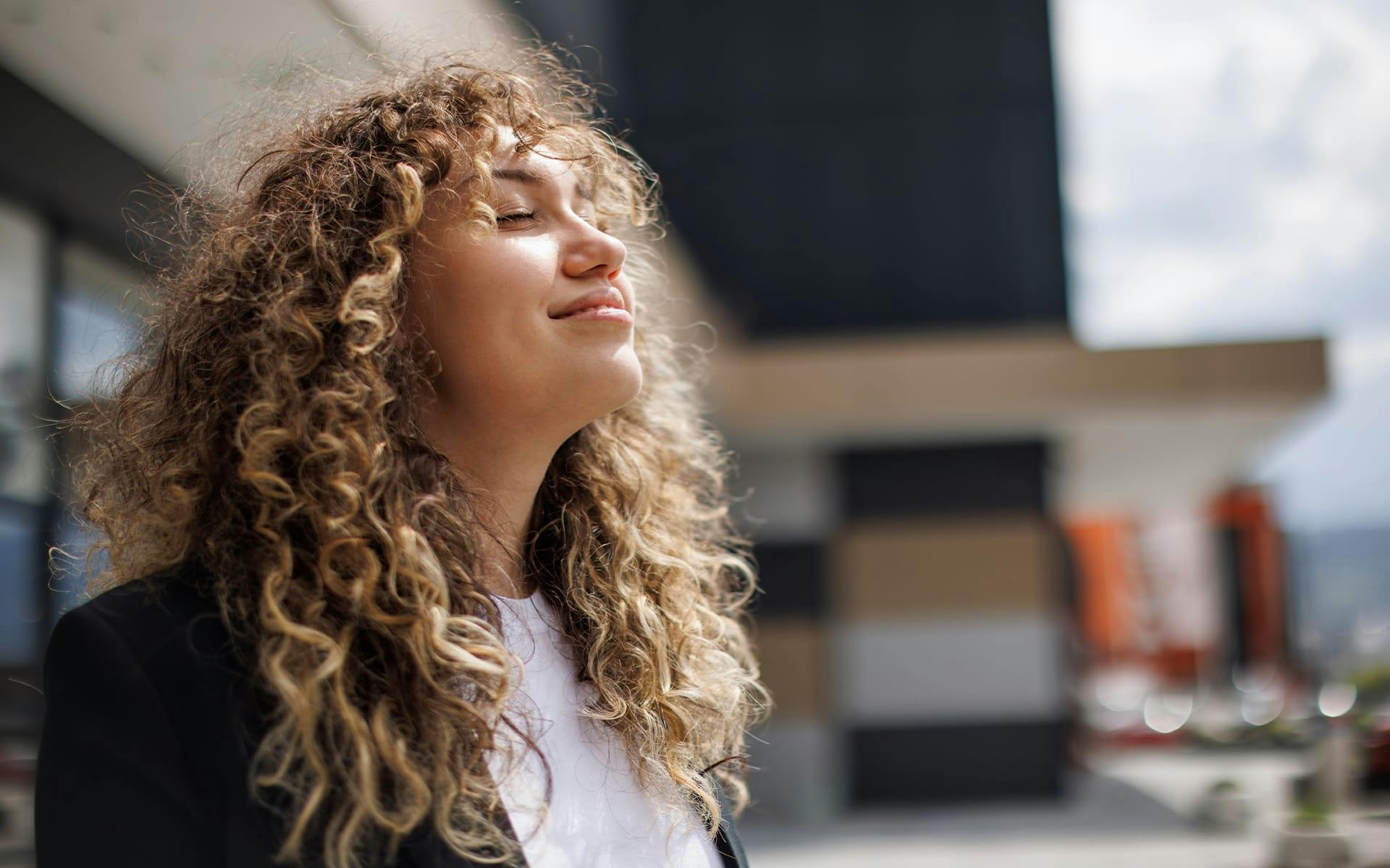 woman with curly hair facing upwards