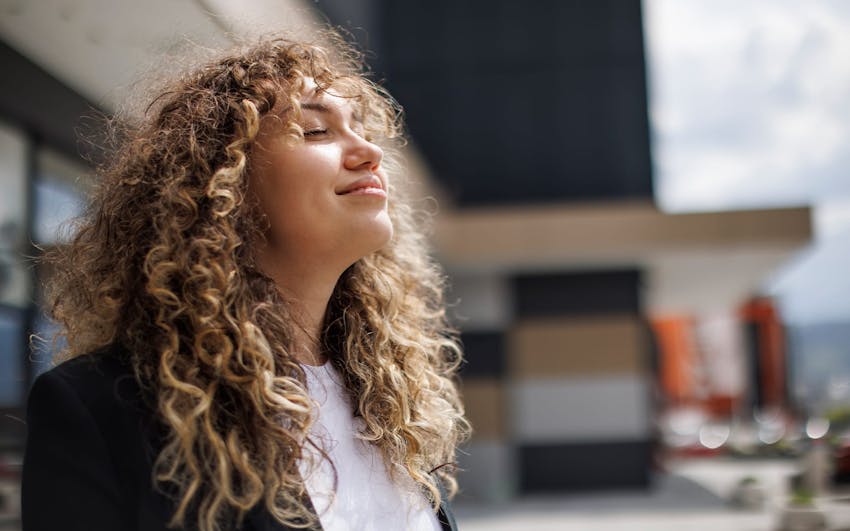 woman with curly hair facing upwards