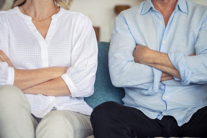 Older couple sitting with their arms crossed