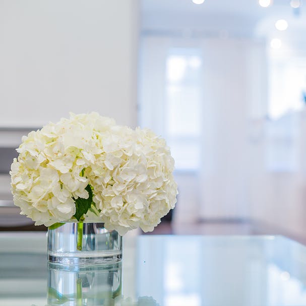 A vase with flowers on a glass table