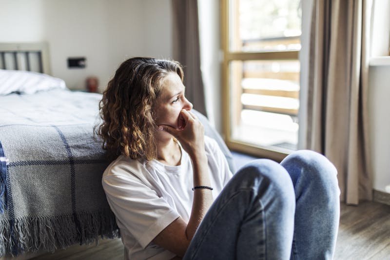 young woman sitting on floor alone