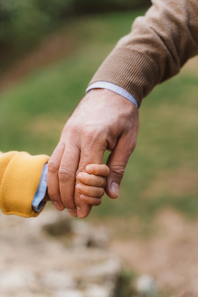 A man holding hands with a child