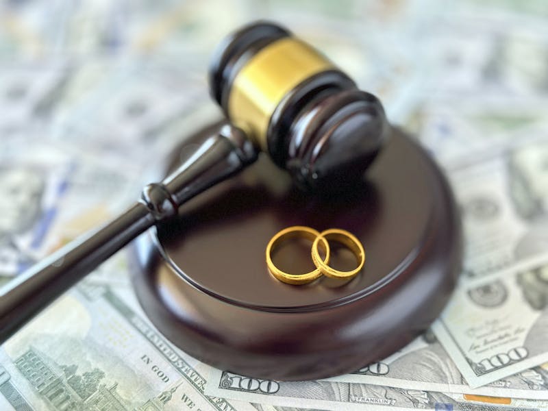 A gavel and rings on a pile of cash