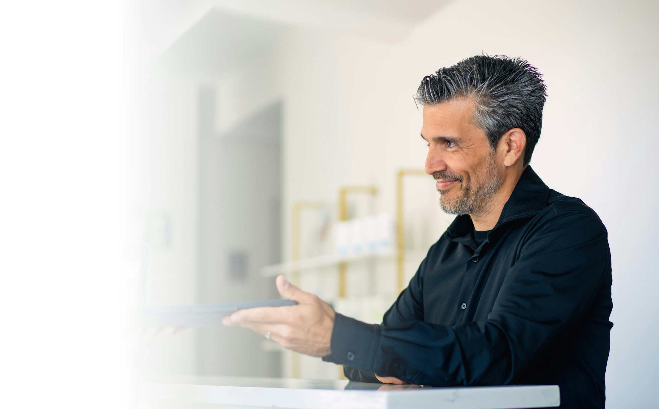 man handing a tablet to staff member