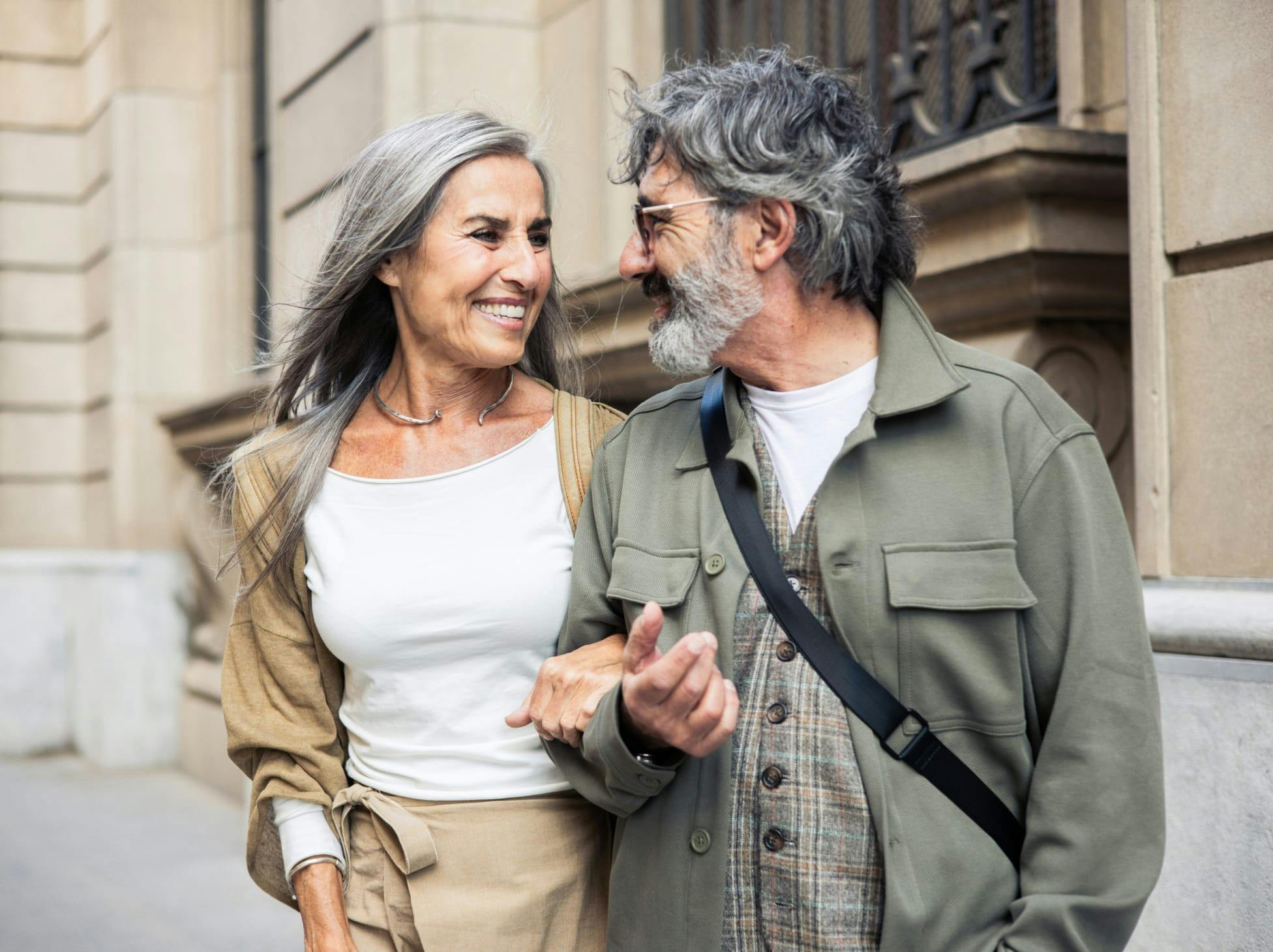 older couple walking with their arms interlinked