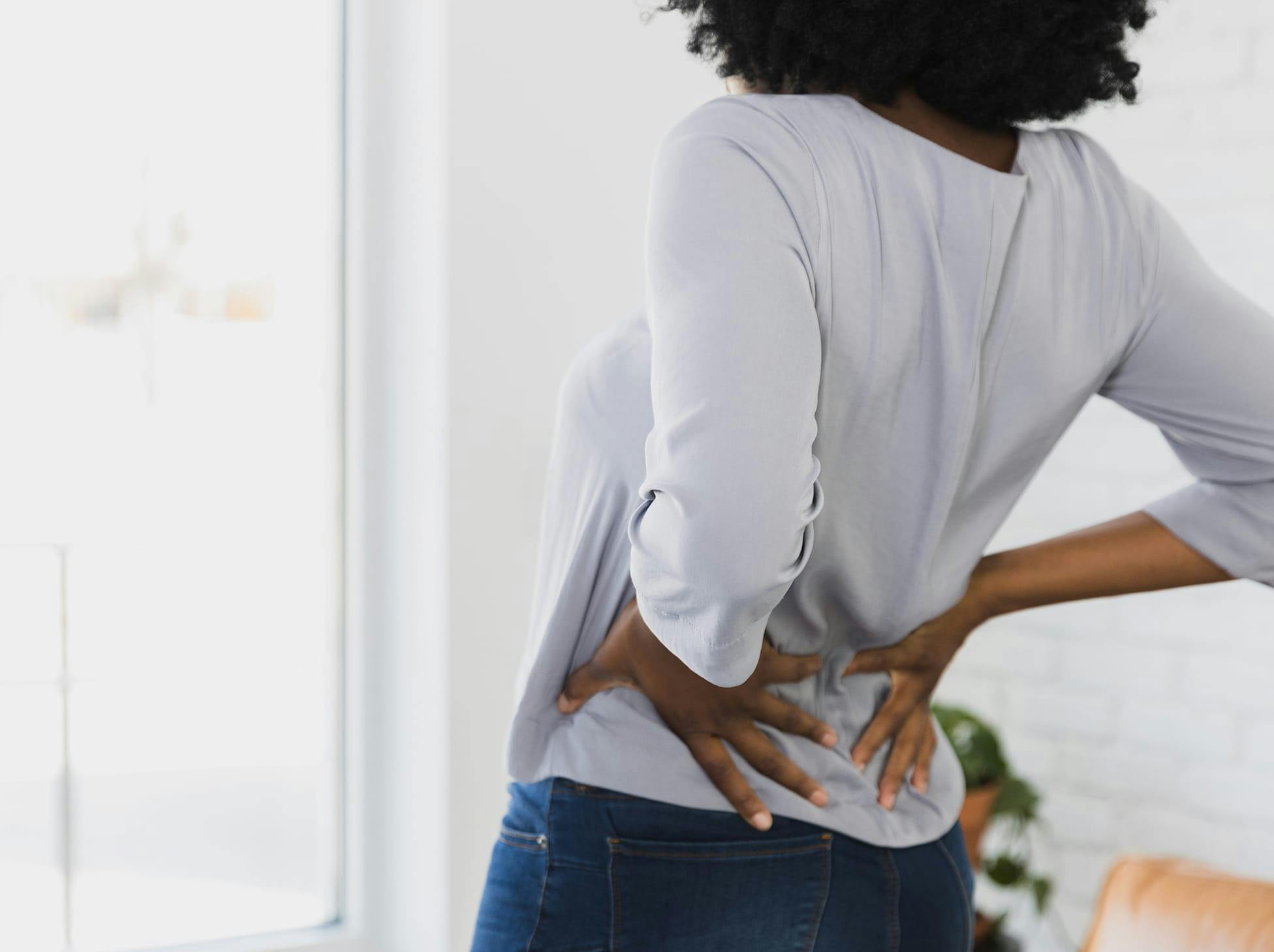 woman holding her lower back