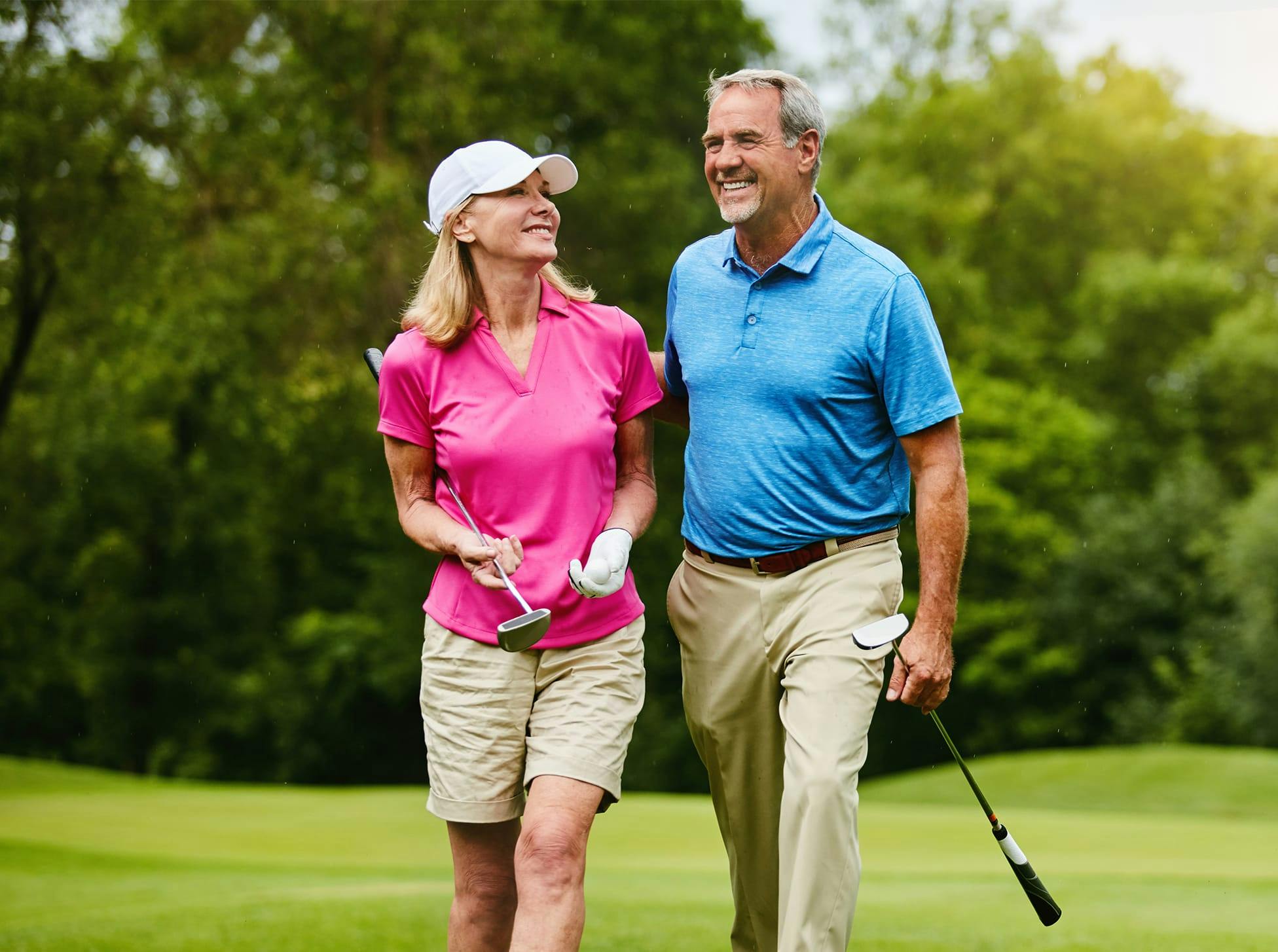 man and woman walking with golf clubs