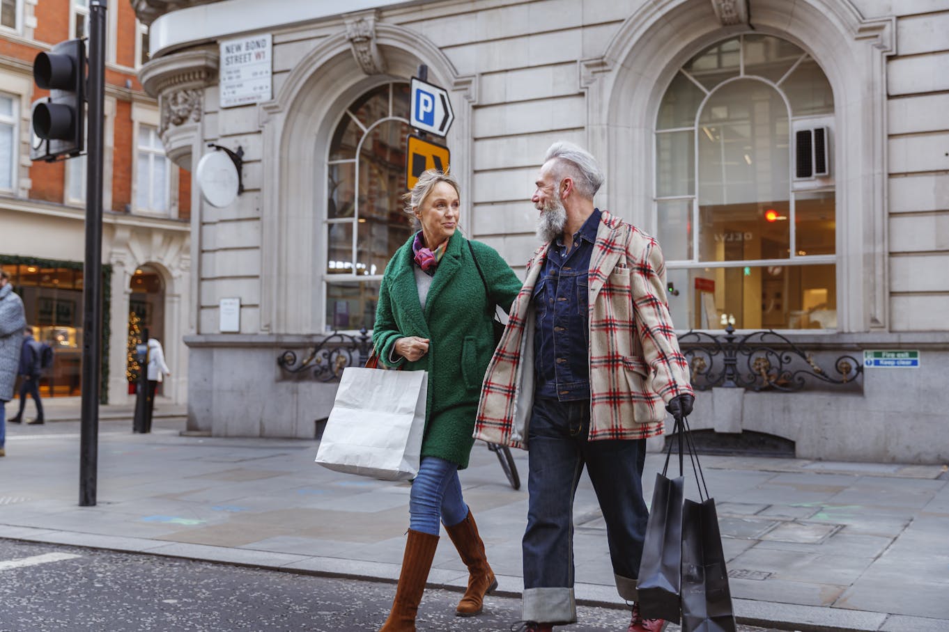 older couple walking down street with shopping bags