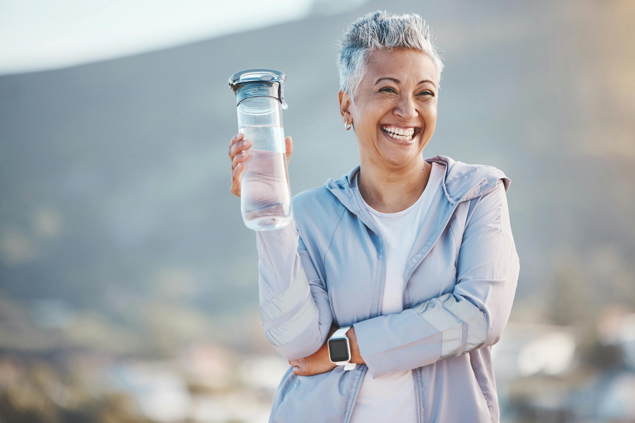 Woman holding water bottle in exercise clothes