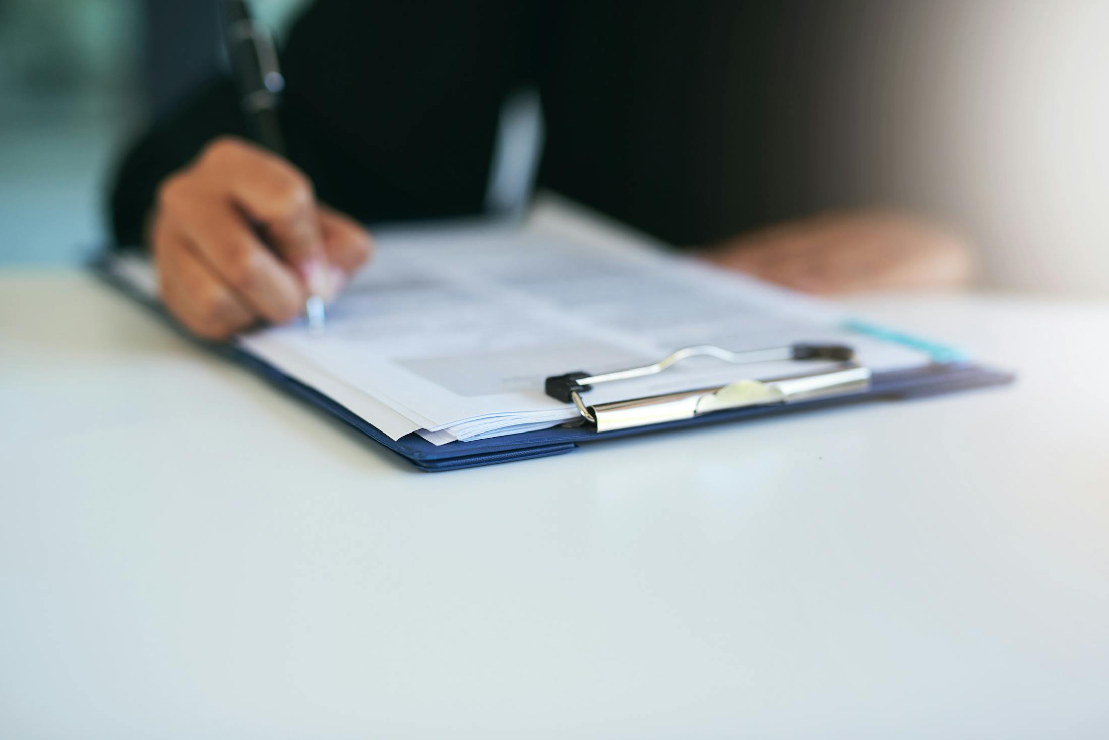 clipboard with paper being signed