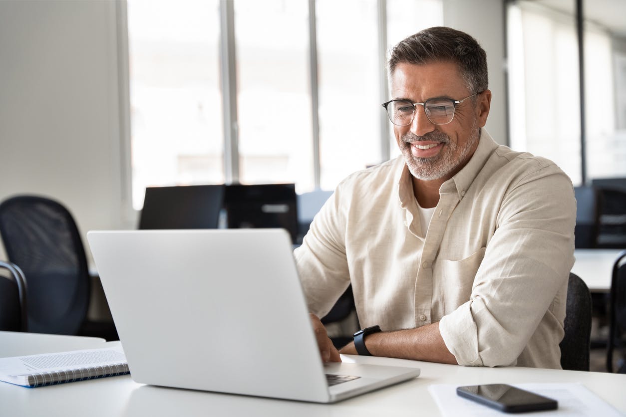 man smiling at laptop computer