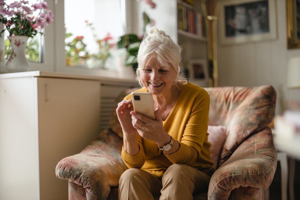 Senior woman using mobile phone at home