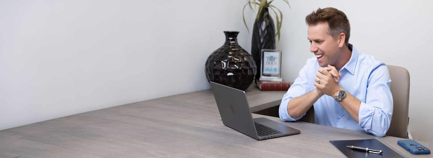 Dr. Gorscak smiling at laptop