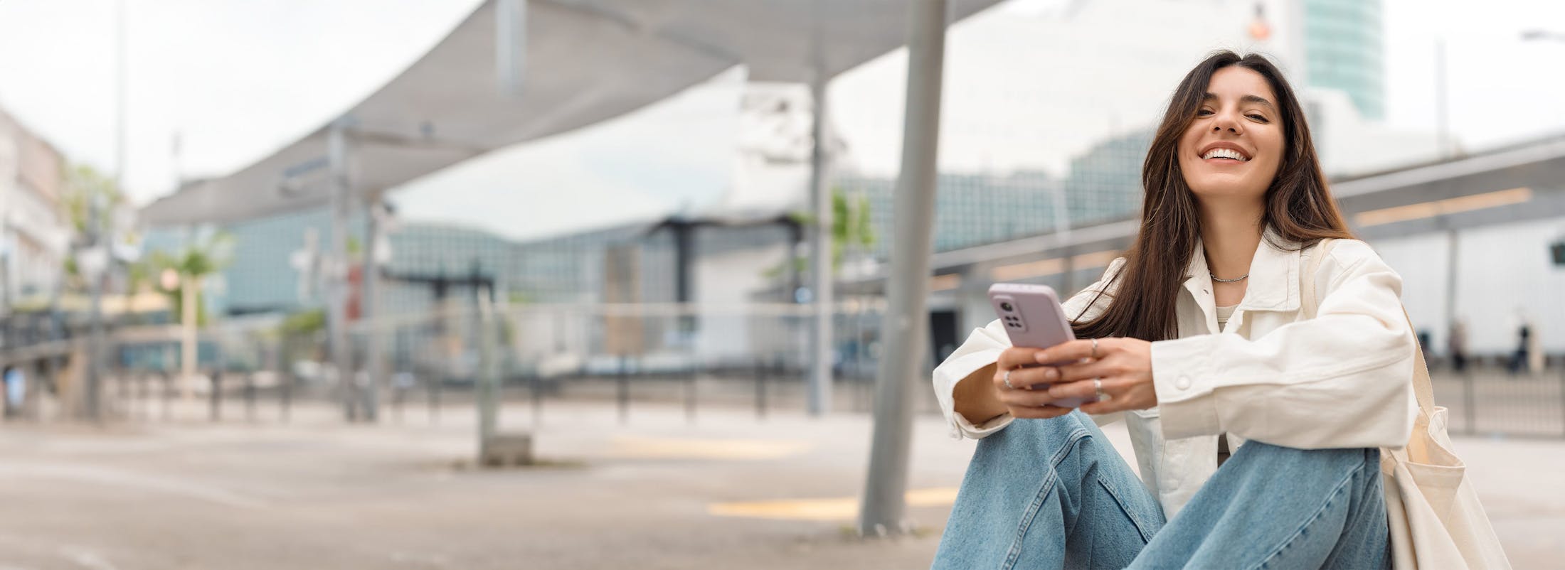 Smiling woman  holding phone outside