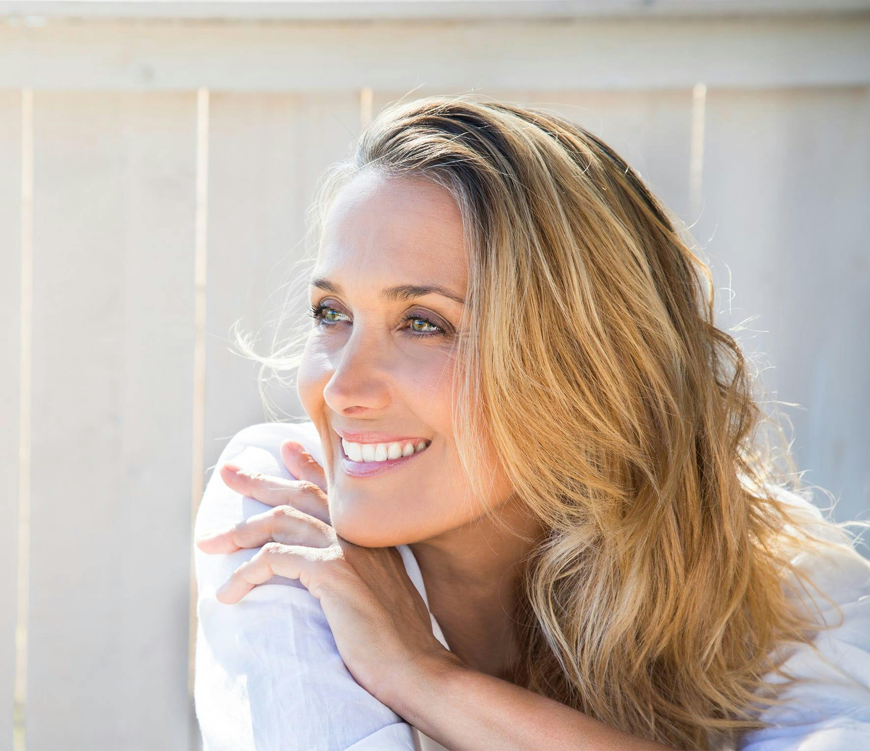 Blonde woman smiling over her shoulder