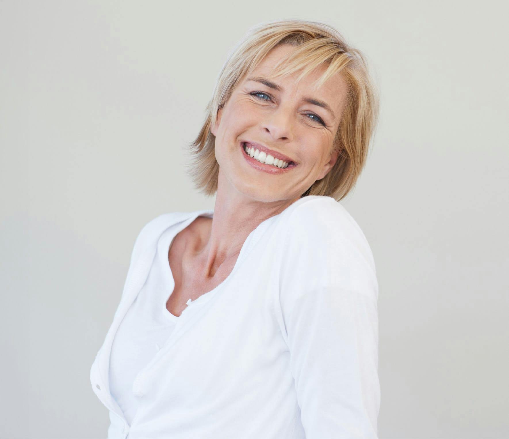 Blonde woman smiling over her shoulder