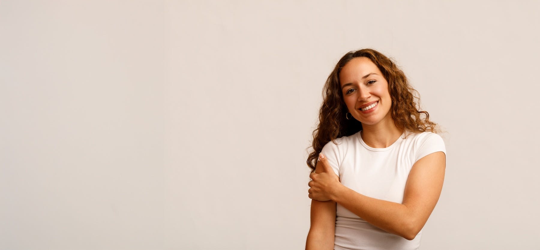 18-45 - Women smiling towards camera and holding arm