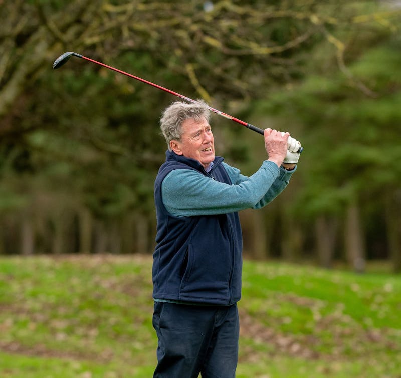 older man playing golf