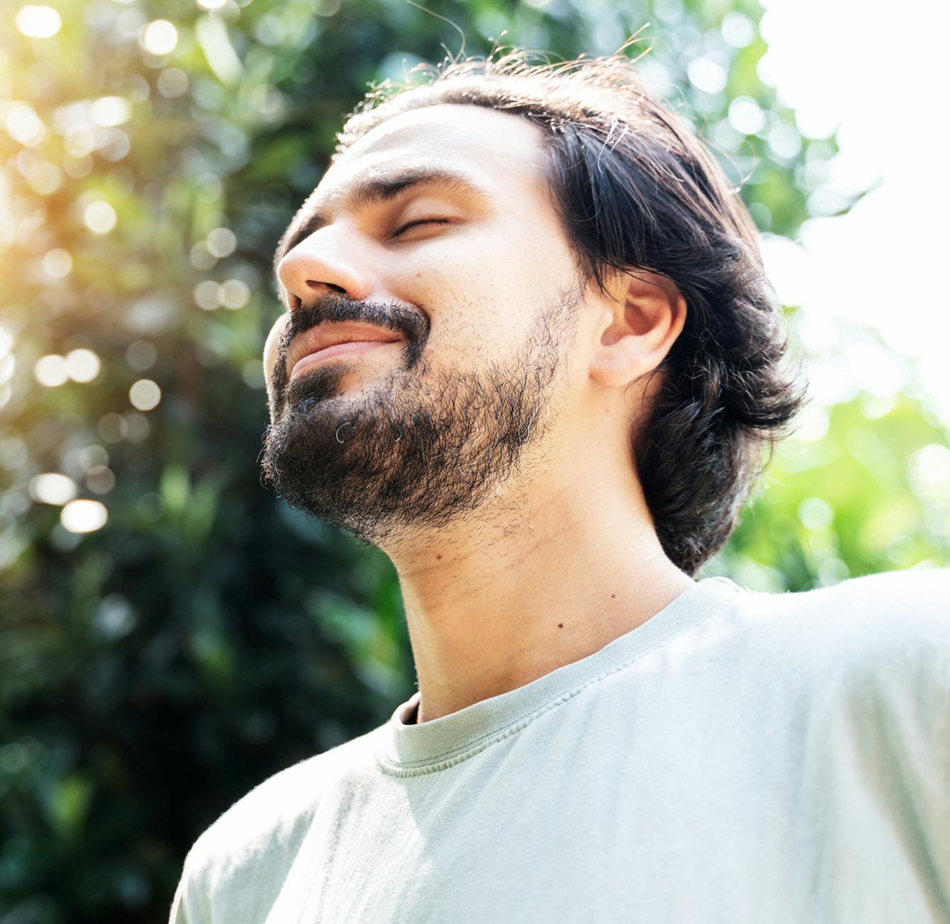 man smiling with his eyes closed outside