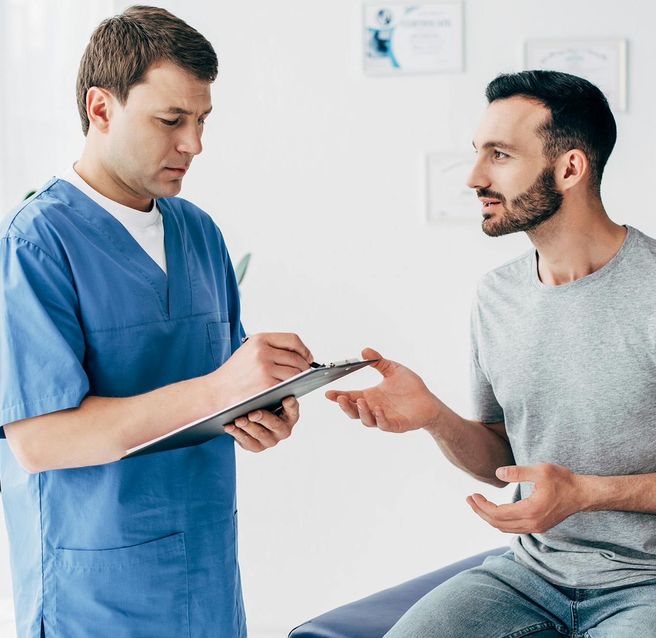Dr consulting a patient, taking notes on a clipboard