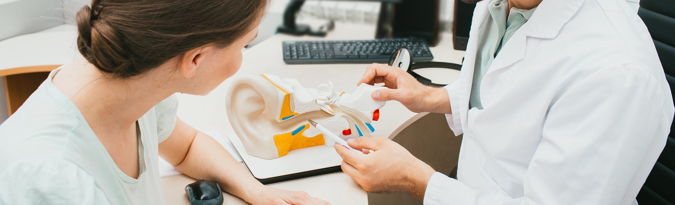 woman looking at a diagram of an ear with a doctor